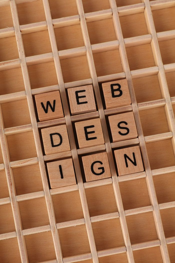 Crafting Captivating Headlines: Your awesome post title goes here Wooden blocks spell 'WEB DESIGN' on a grid, ideal for digital themes.